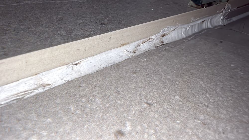 Sealant failed at the shower step-down, letting water past the threshold, found during a defect investigation inspection in Pascoe Vale